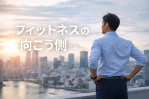 夕暮れの都市を見渡すビジネスパーソンの後ろ姿｜フィットネスの向こう側